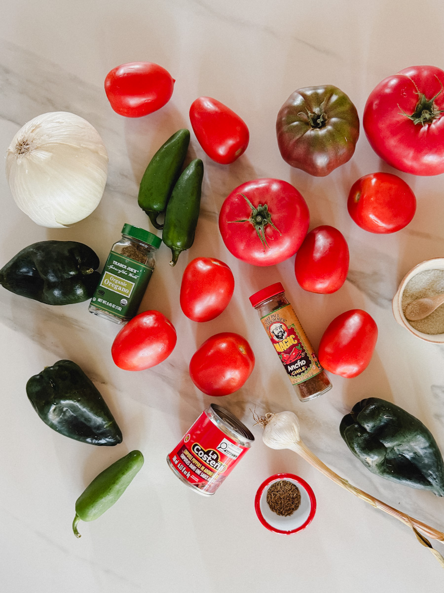ingrédients pour salsa maison aux tomates et piments grillés sur comptoir marbré blanc