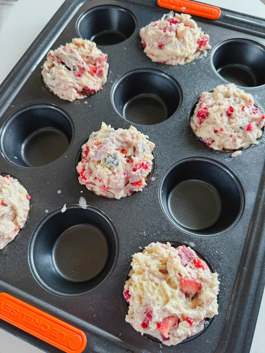 moule à muffin avec pâte à muffin qui déborde, non cuite