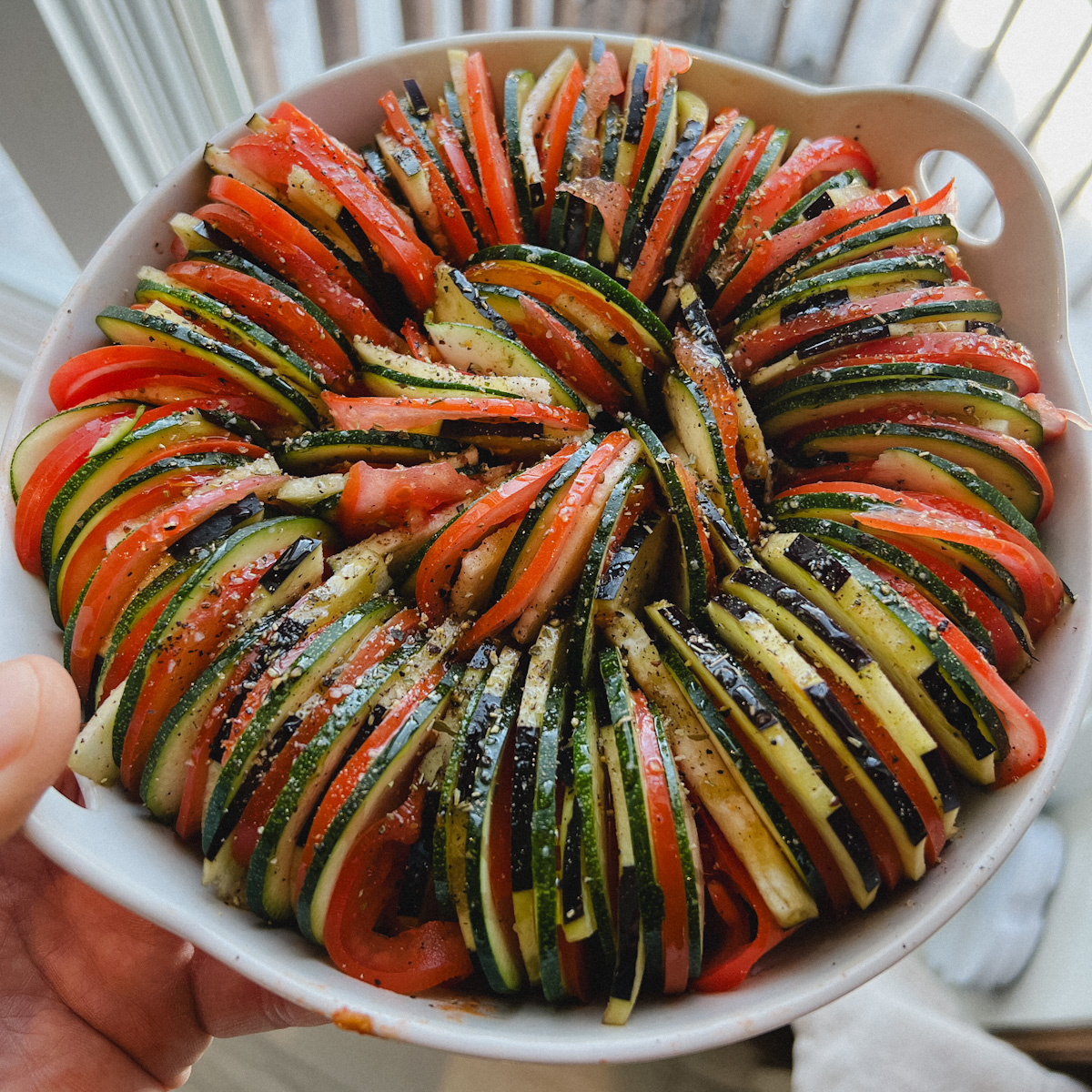 tian de légumes non cuit, belle spirale de légumes en fines blanc rondelles dans un plat blanc