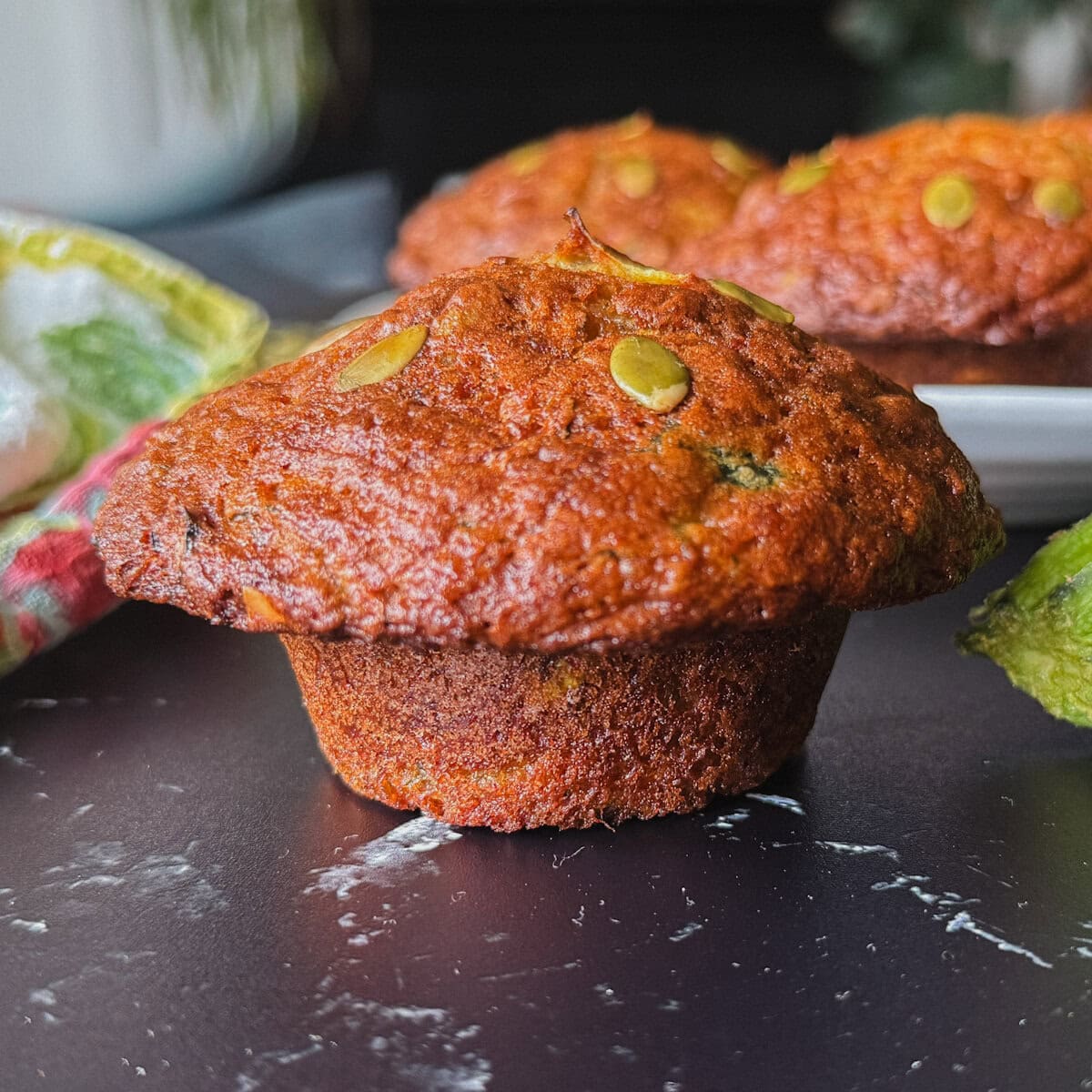 muffin aux courgettes avec gros chapeau doré sur comptoir marbré noir