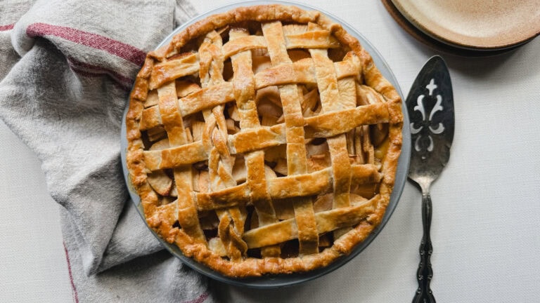 tarte aux pommes traditionnelle, avec linge en lin naturel, cuillère de service et assiettes desserts en poterie grège