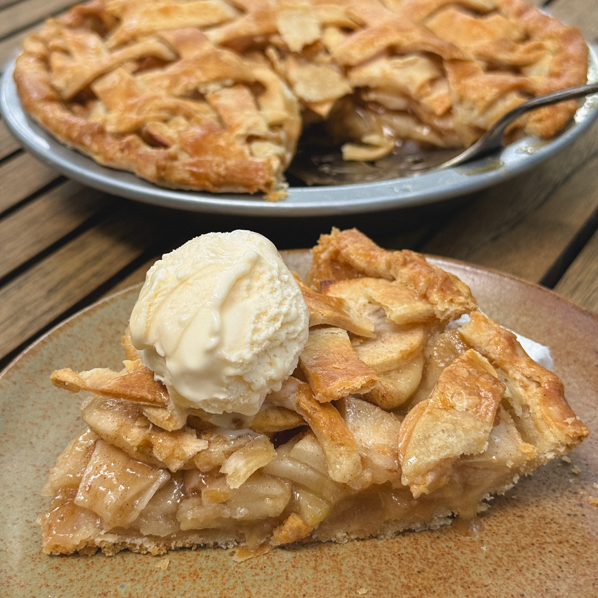 pointe de tarte aux pommes avec boule de crème glacée, tarte visible en arrière plan
