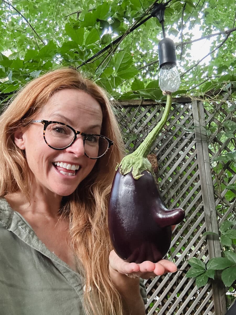 Manon Lapierre (La petite bette) qui tient une aubergine mignonne avec un nez dans sa main