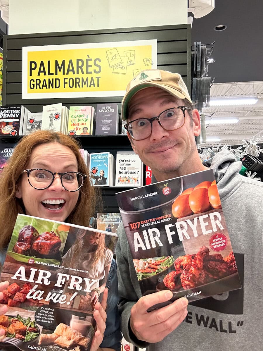 Manon Lapierre et Lionel du Souich de La petite bette qui tiennent leurs deux livres de recettes air fryer devant le tableau du palmares chez Renaud Bray