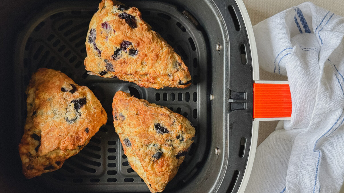 3 scones aux bleuets dans le panier du air fryer, linge sur le tiroir