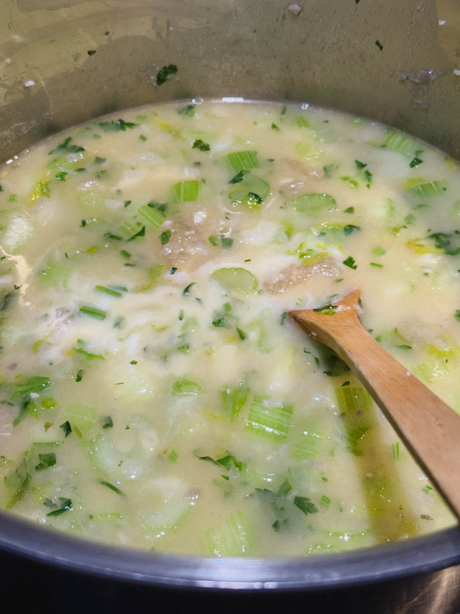 lait et bouillon et céleri dans casserole avec cuillère en bois