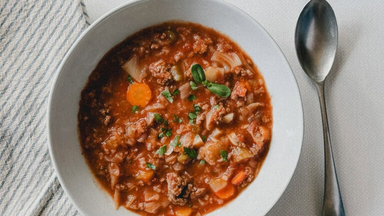 soupe style cigare au chou dans un bol blanc avec cuillère et linge de table à côté