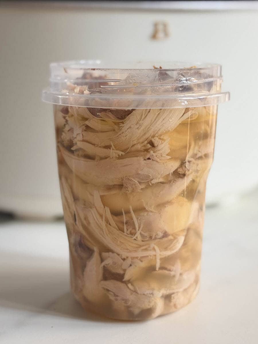 poulet et bouillon dans un pot devant une mijoteuse