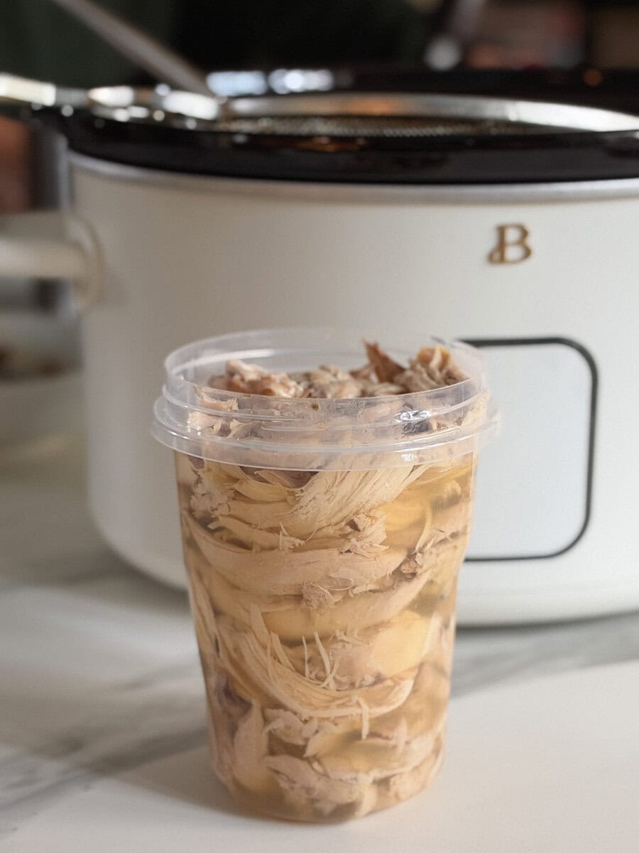pot de poulet dans son bouillon devant une mijoteuse blanche