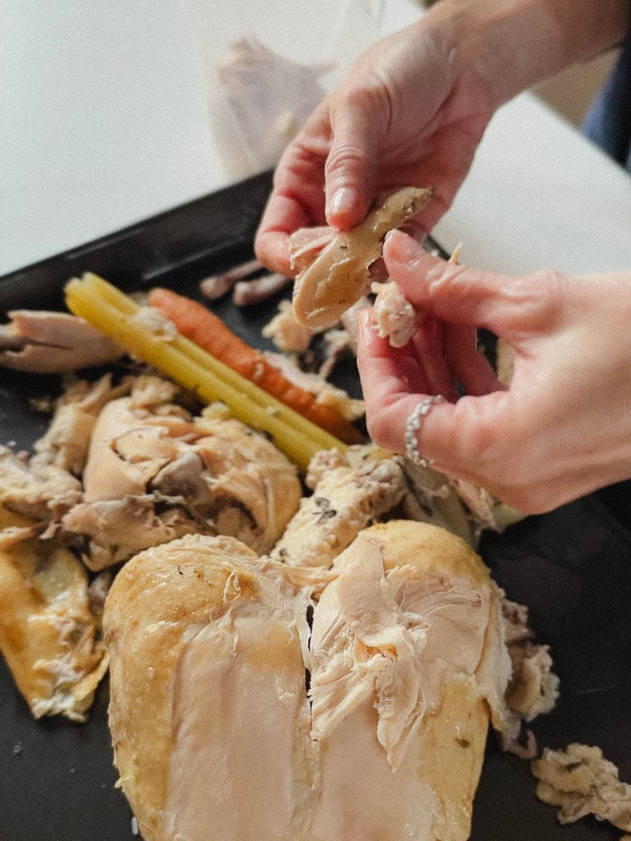 main qui effiloche du poulet cuit