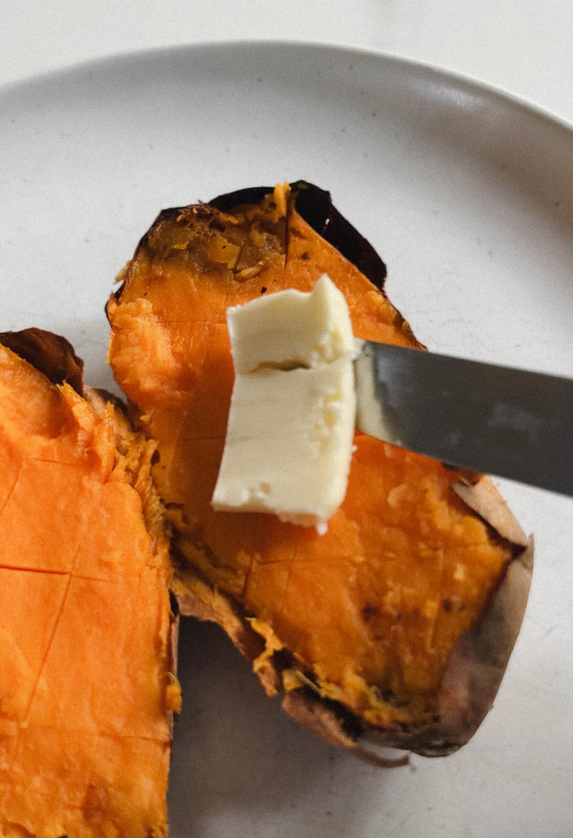 couteau qui met du beurre sur patate sucrée cuite