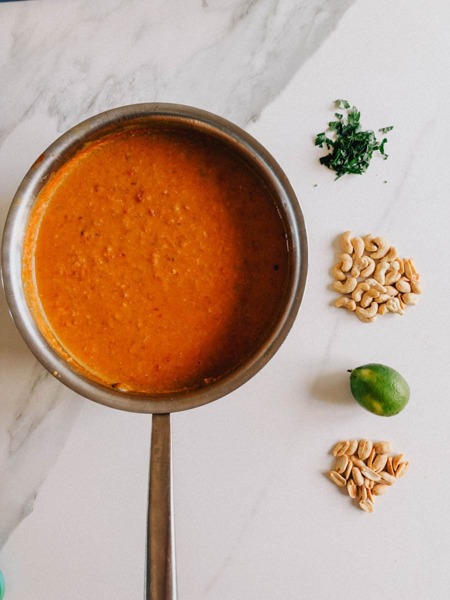 soupe aux lentilles corail dans casserole avec garnitures à côté