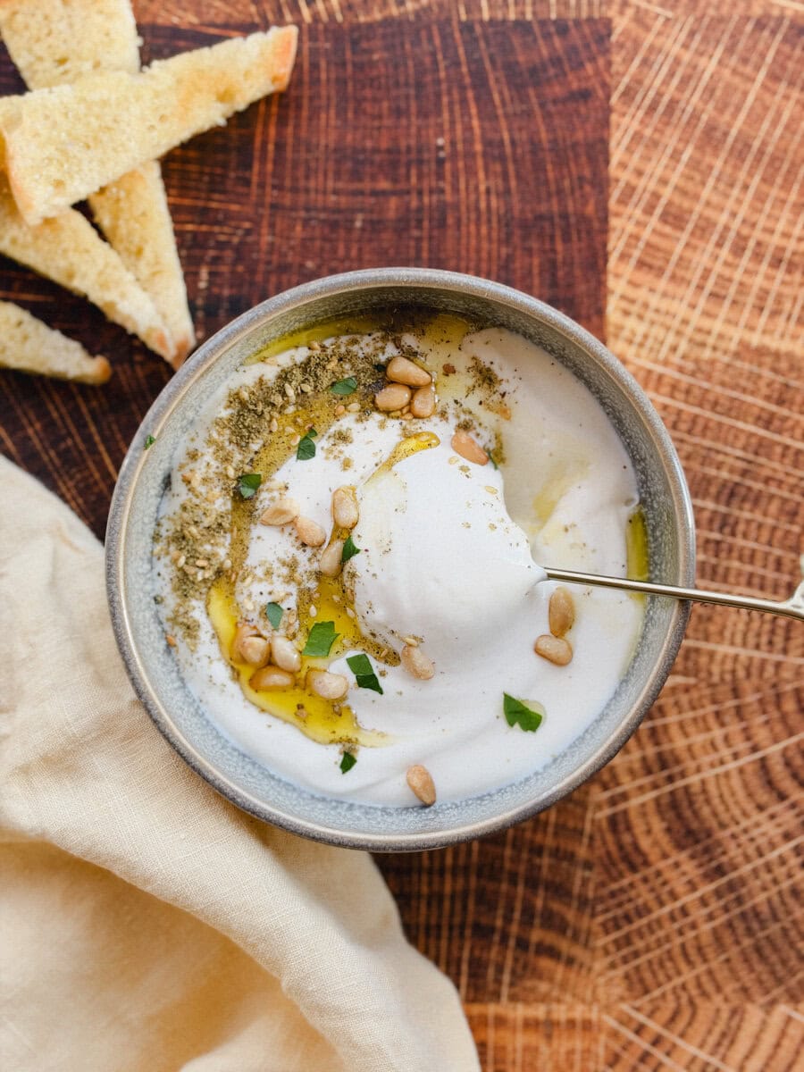 bol de feta fouetté avec cuillère dorée et croûtons de pain avec linge de table