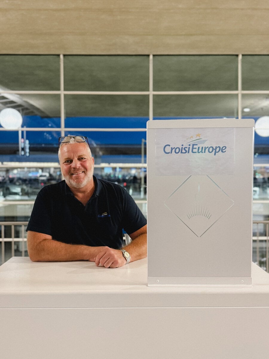 représentant CroisiEurope à CDG souriant derrière son comptoir